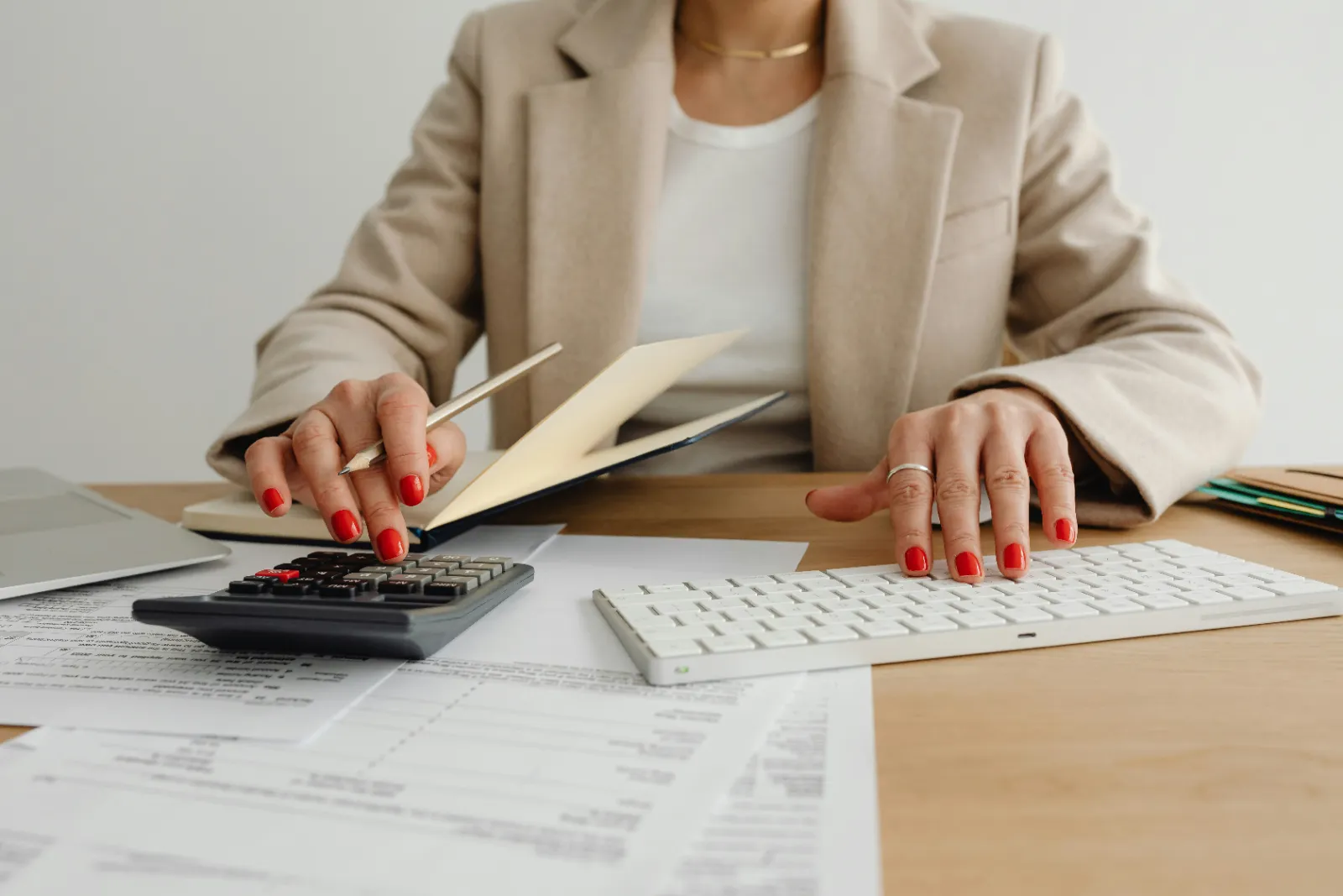 Bookkeeper using a calculator to reconcile payroll and expenses