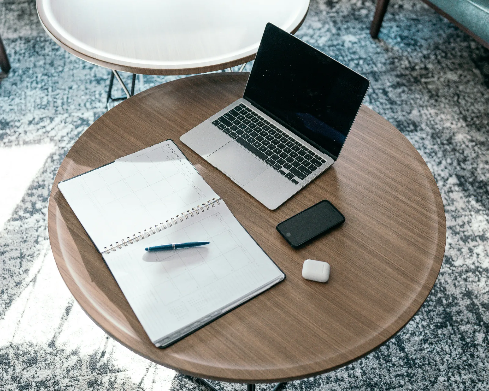 Laptop and notebook on a table for monthly bookkeeping